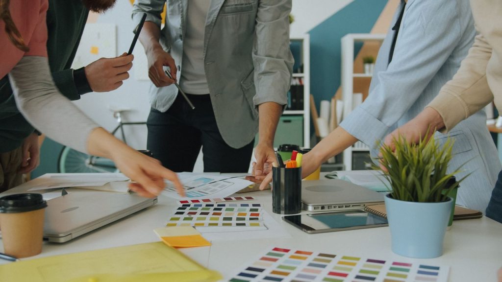 Team collaborating on color samples and design elements in a modern office space.